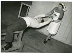 Black and white photograph of a VAD nurse going through exercises with a patient at a Royal Air Force Officers convalescent home