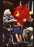 Colour photograph of a member of the Junior Red Cross giving assistance to the elderly