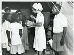 Black and white photograph of a Red Cross VAD giving gifts to children in Sudan