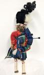 Small woollen doll dressed as a Bagpiper